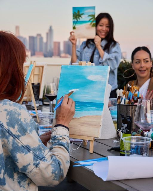 Close-up of a guest's beach painting in progress during a Wellness Atelier guided painting class